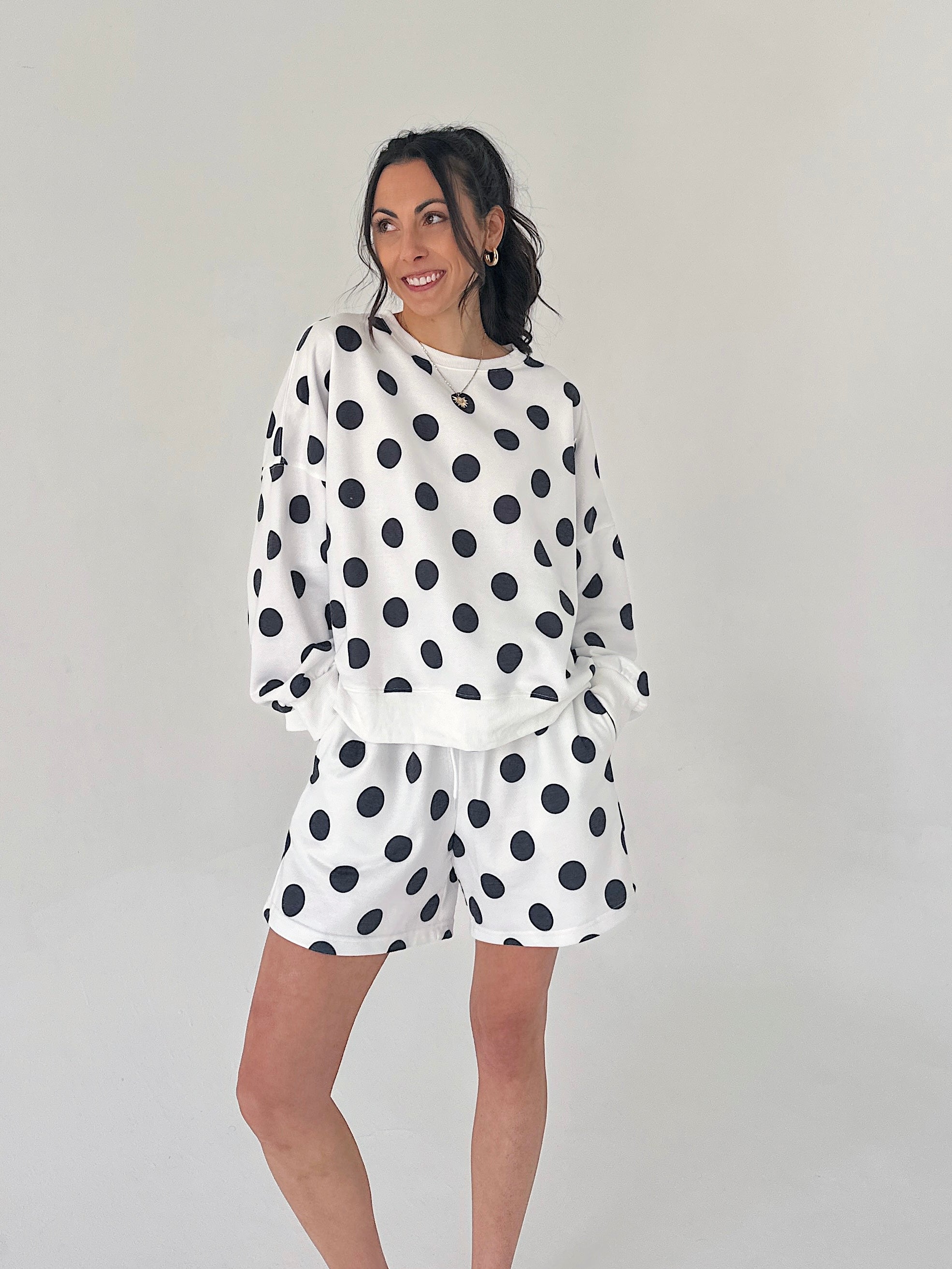 Woman wearing a polka dot outfit on a plain background