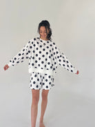 Woman wearing a polka dot outfit on a plain background