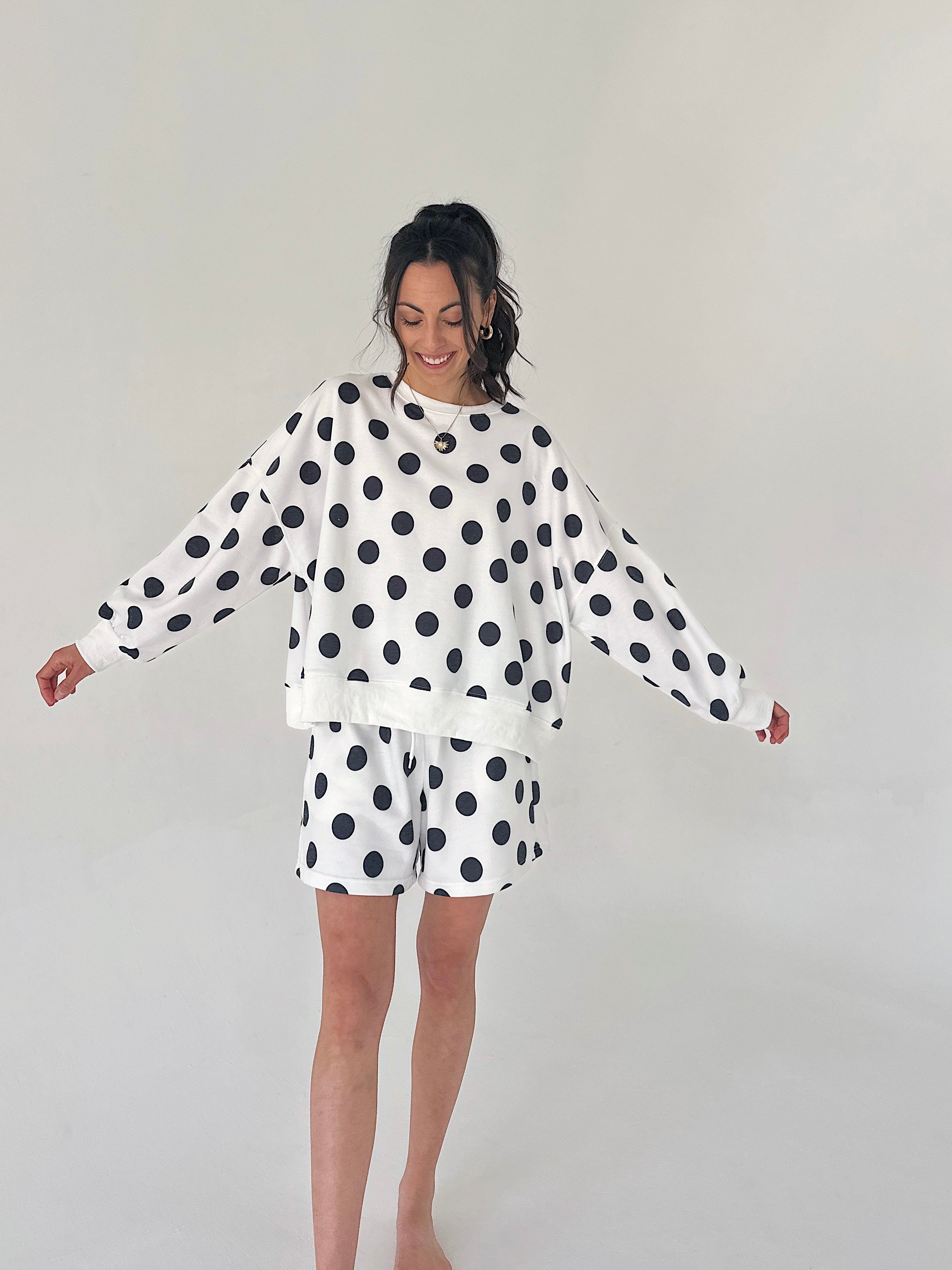Woman wearing a polka dot outfit on a plain background