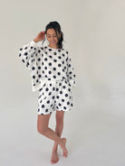 Woman wearing a polka dot outfit on a plain background