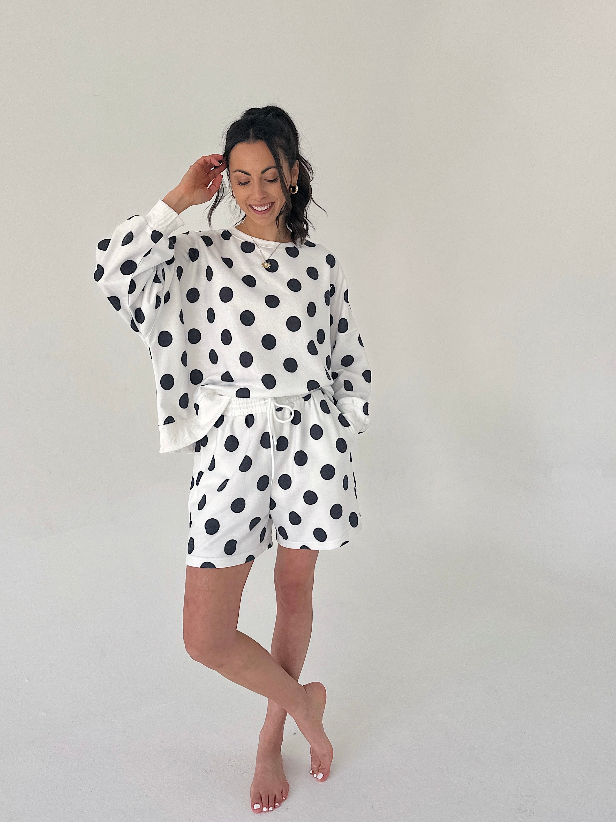 Woman wearing a polka dot outfit on a plain background