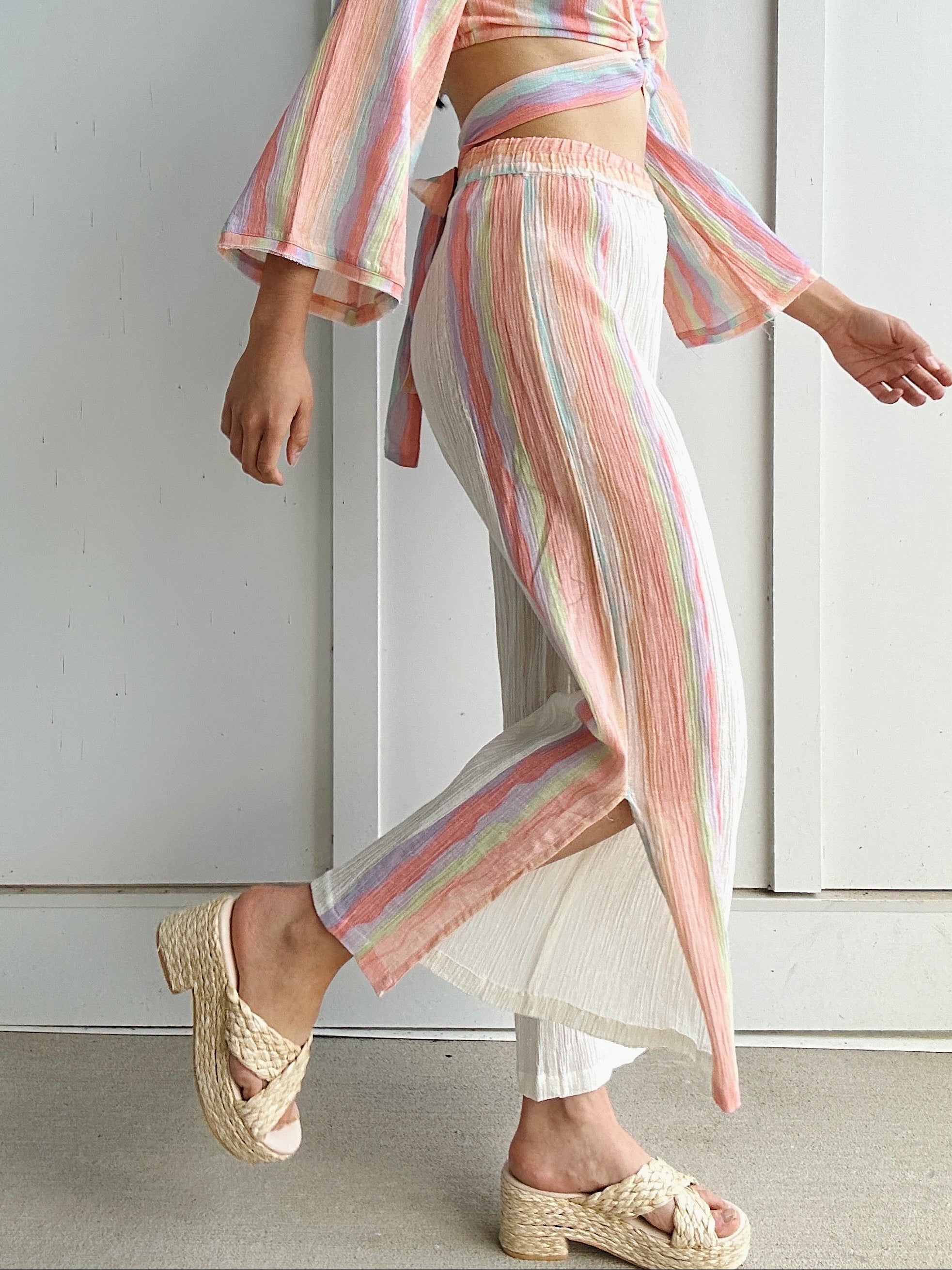 woman wearing wide leg light weight pants with colorful side stripes
