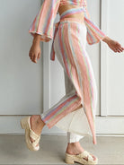 woman wearing wide leg light weight pants with colorful side stripes