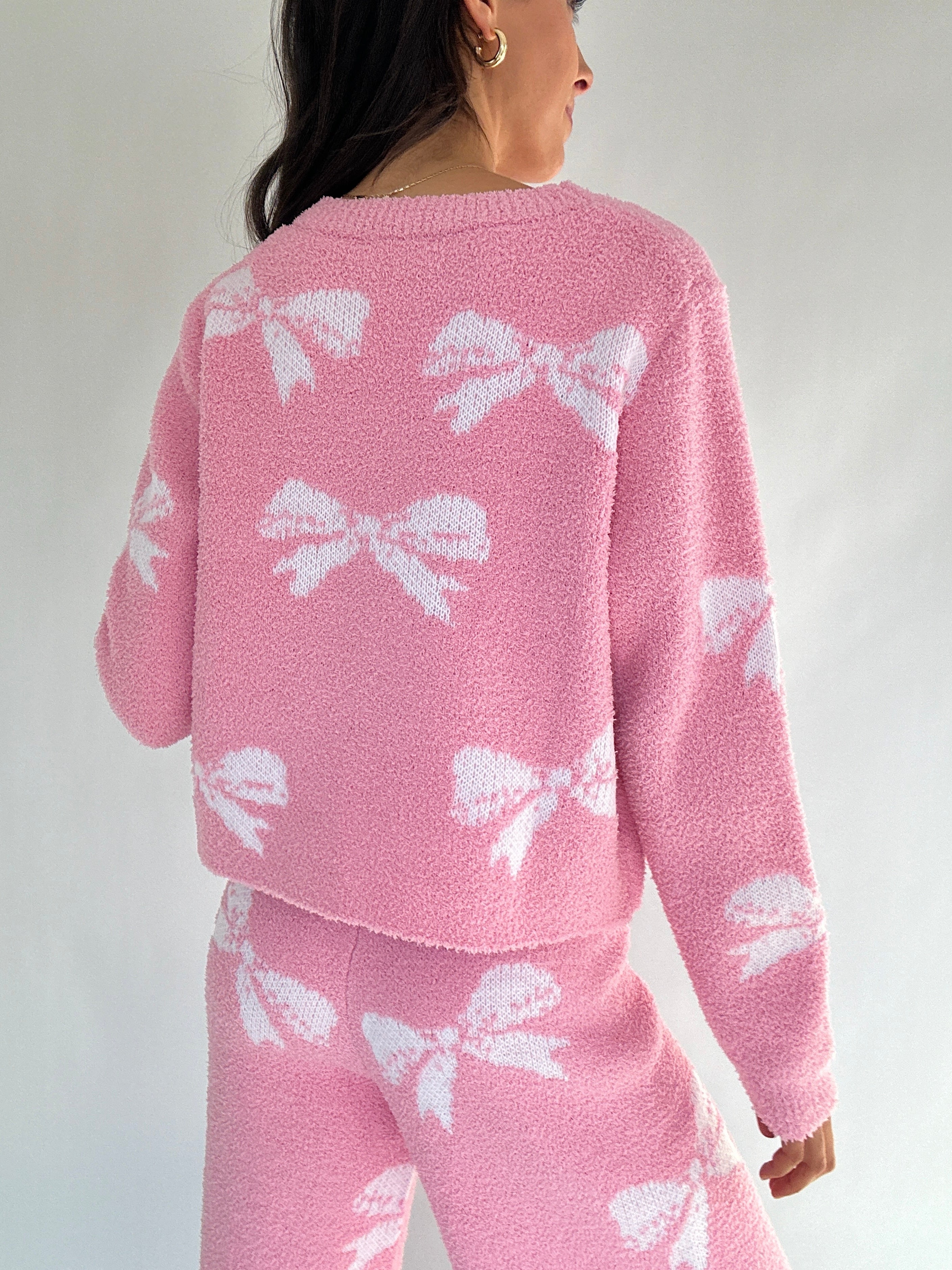 Pink lounge set with white bow patterns on a plain background showing back of top