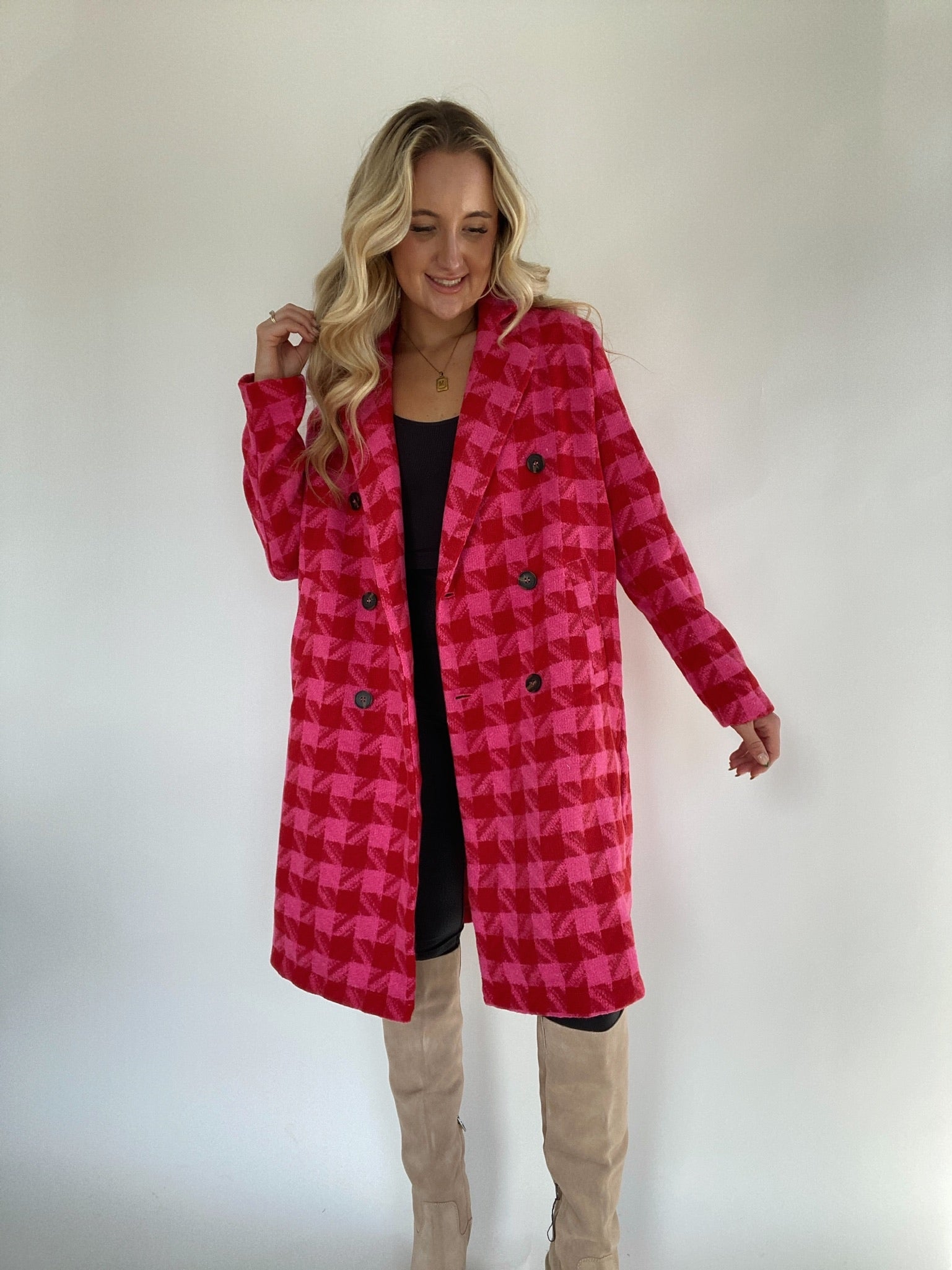 Woman wearing houndstooth coat in pink and red