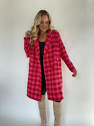 Woman wearing houndstooth coat in pink and red