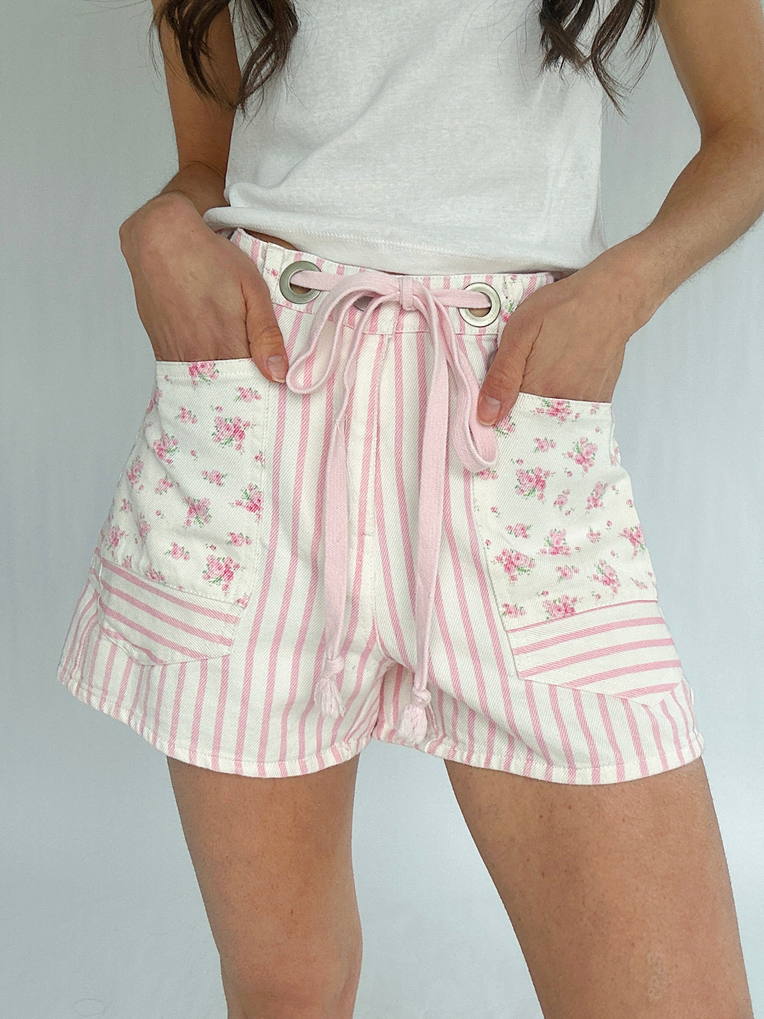 Shorts with pink floral and striped pattern on a plain background