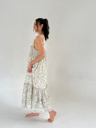 Woman wearing a white floral dress with a plain background