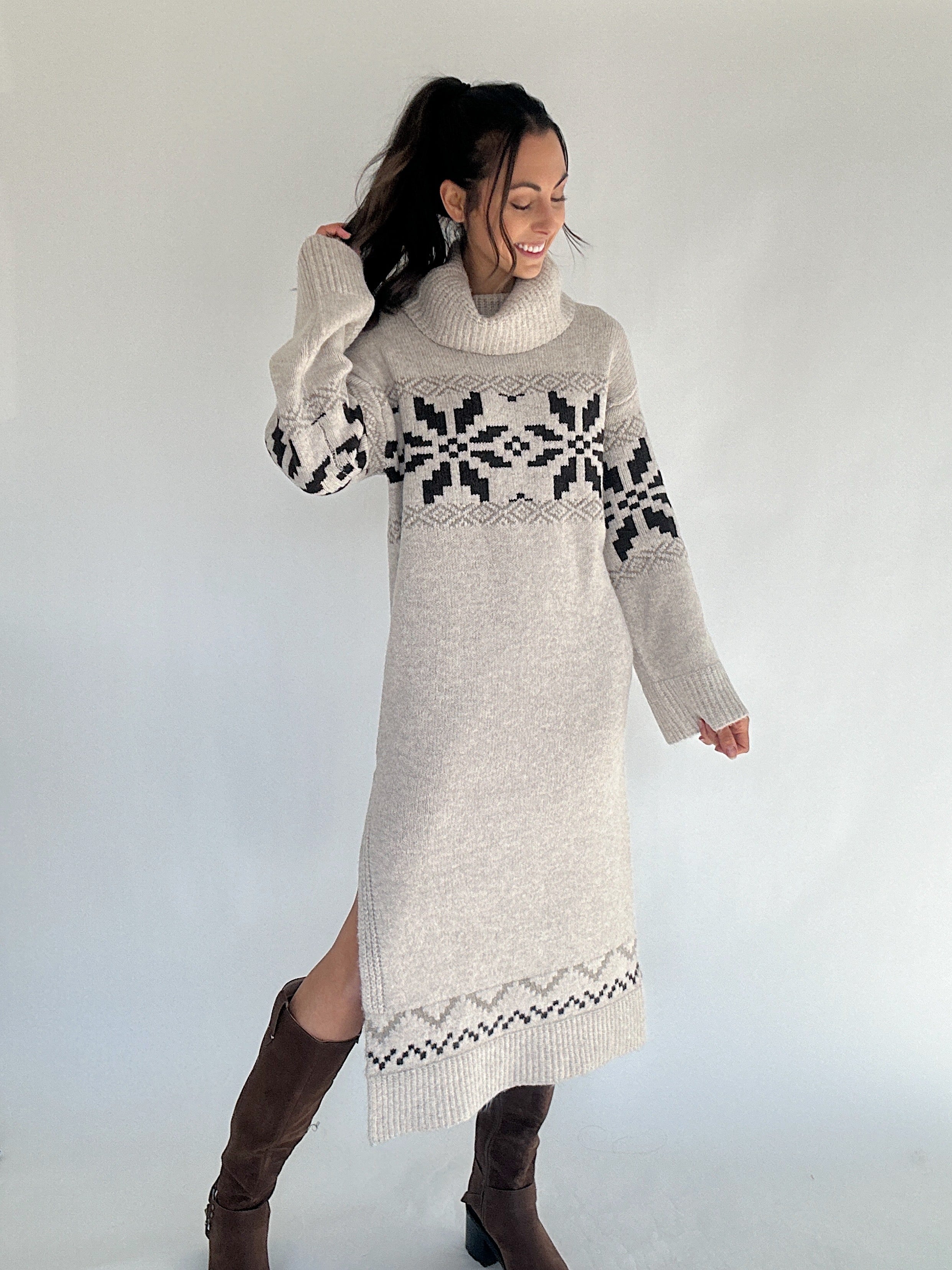 Woman wearing a long, patterned sweater dress against a plain background