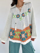Person wearing a floral-patterned chenille knit sweater with a white background