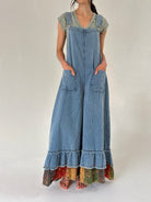 Person wearing denim overalls with colorful hem and front patch pockets on a white background
