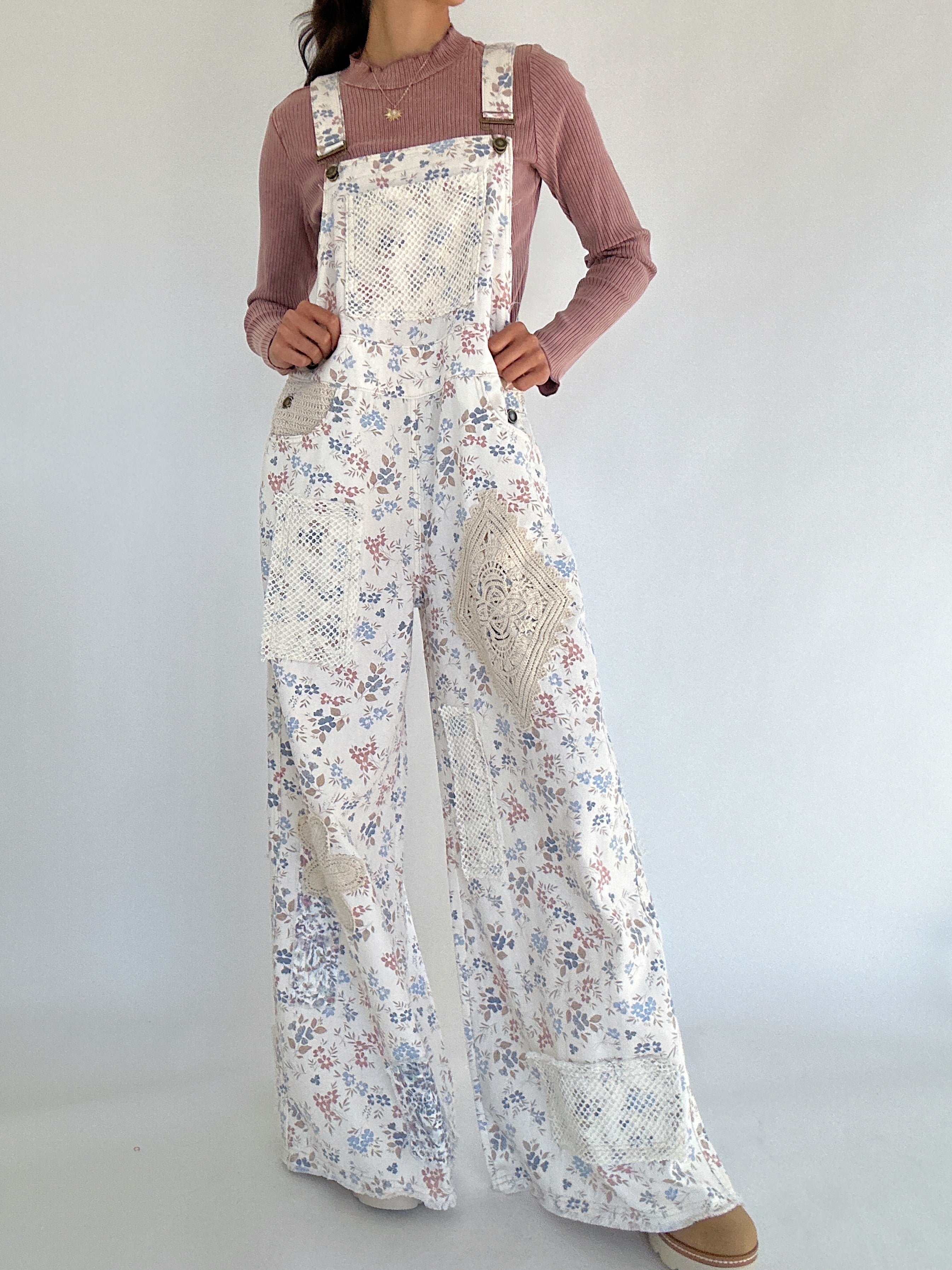 Person wearing a floral overalls with a plain background