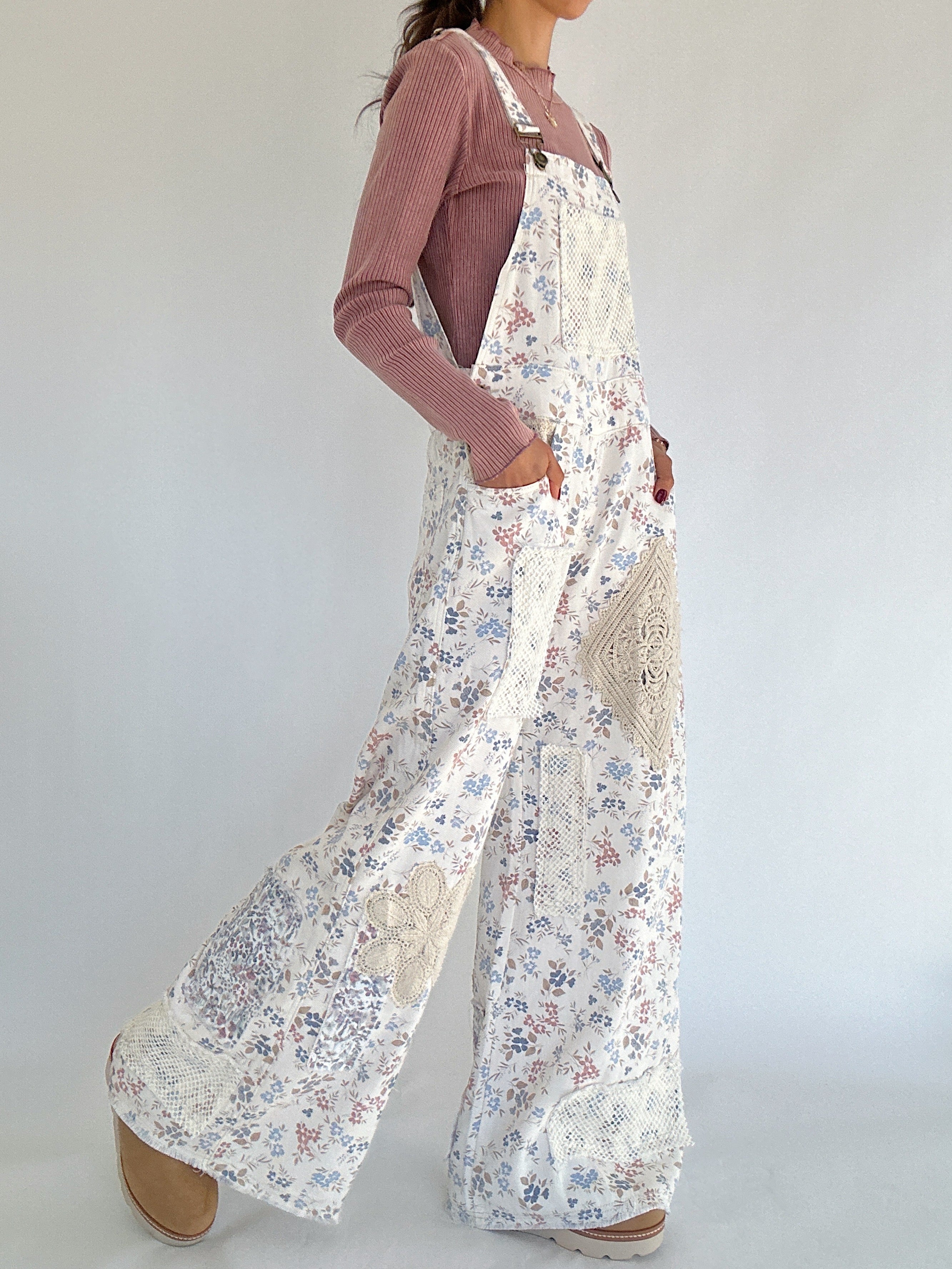 Person wearing a floral overalls with a plain background side view