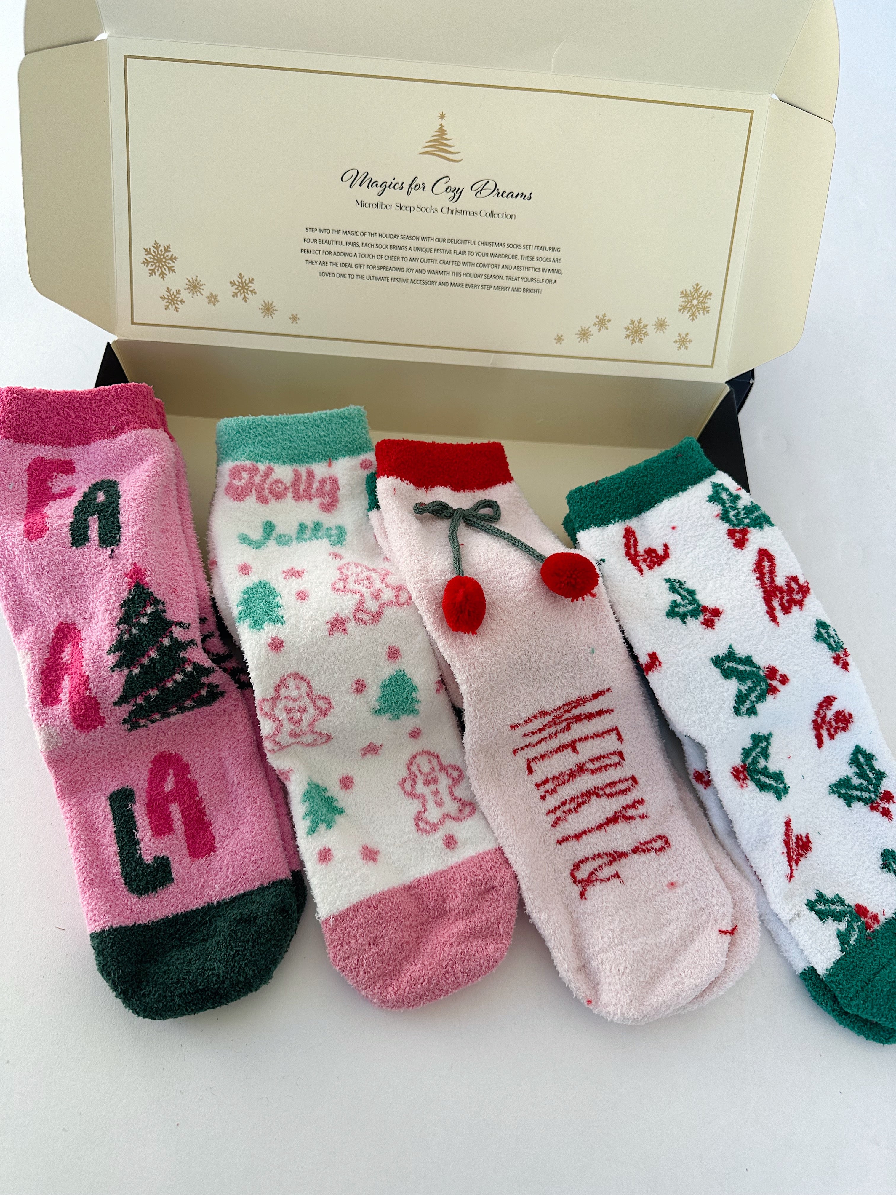 Set of Christmas-themed socks with decorative designs and text, displayed in a branded box.