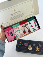 Set of Christmas-themed socks in a decorative box with festive designs.