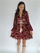 Woman wearing a floral dress with long sleeves on a white background