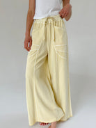 Light yellow wide-leg pants worn by a person on a plain background