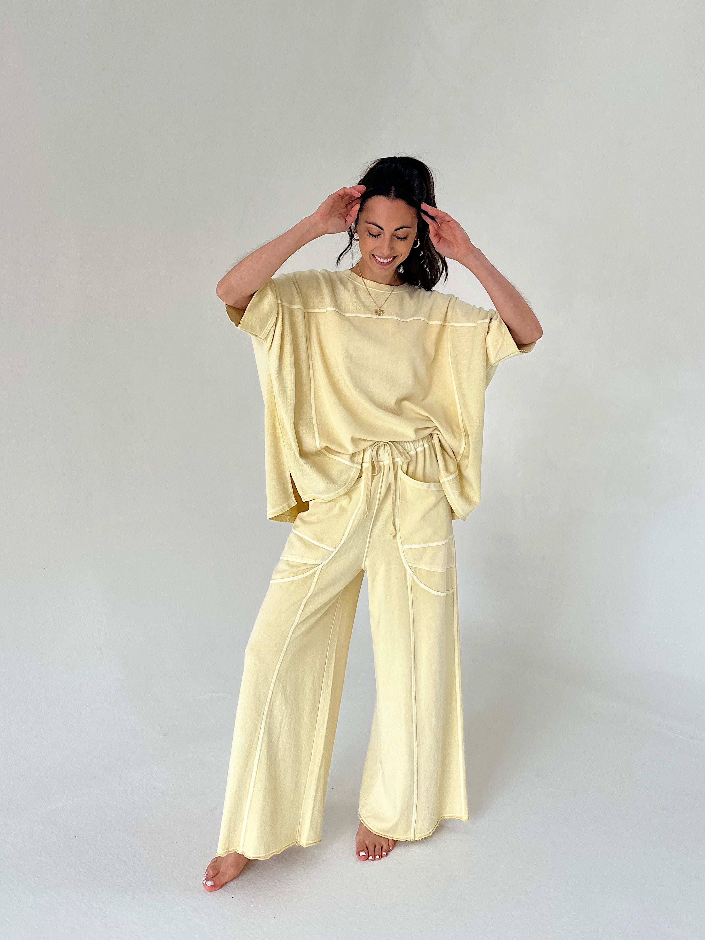 Woman wearing a light yellow outfit on a plain background