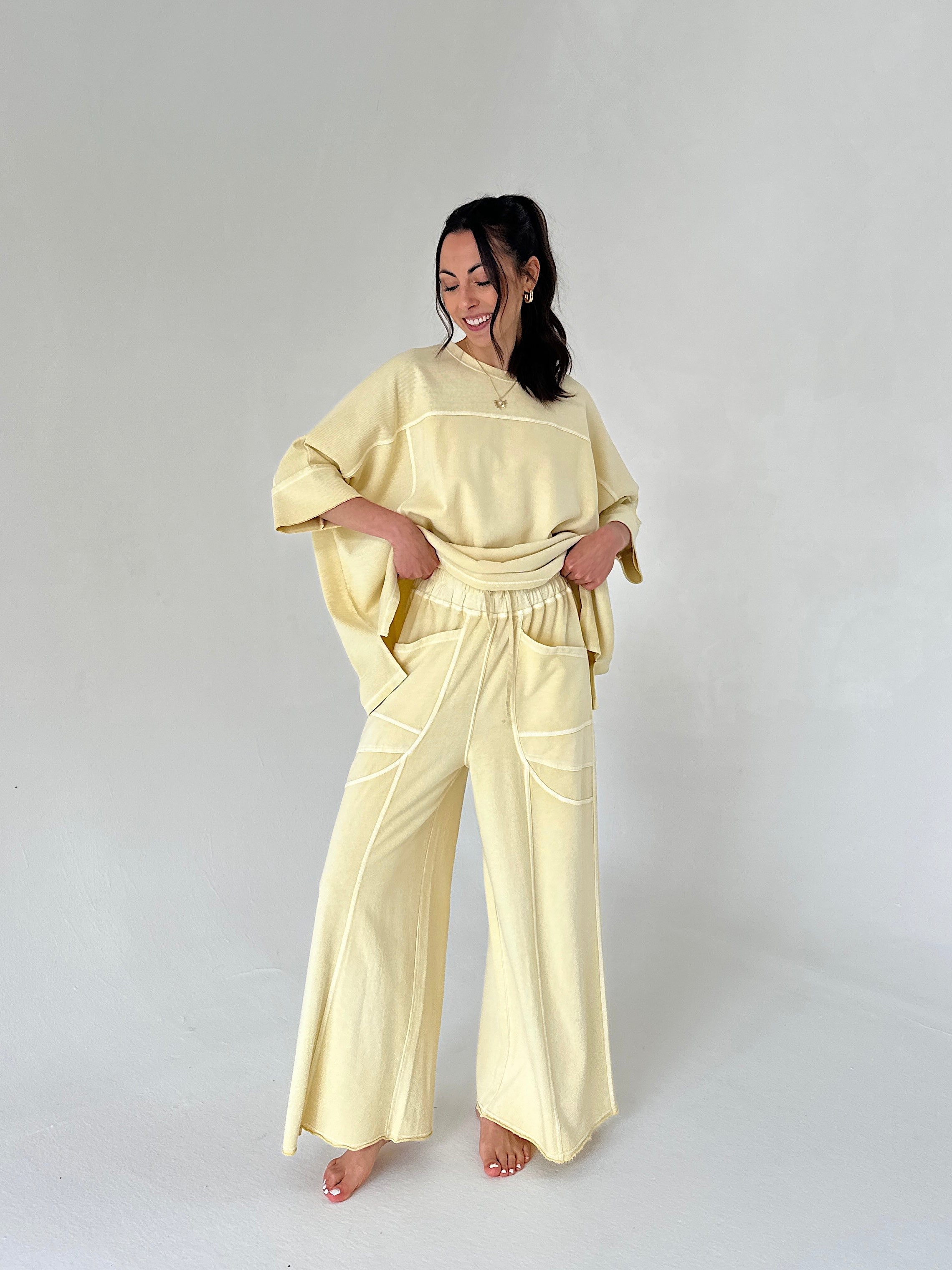Woman wearing a light yellow outfit on a plain background