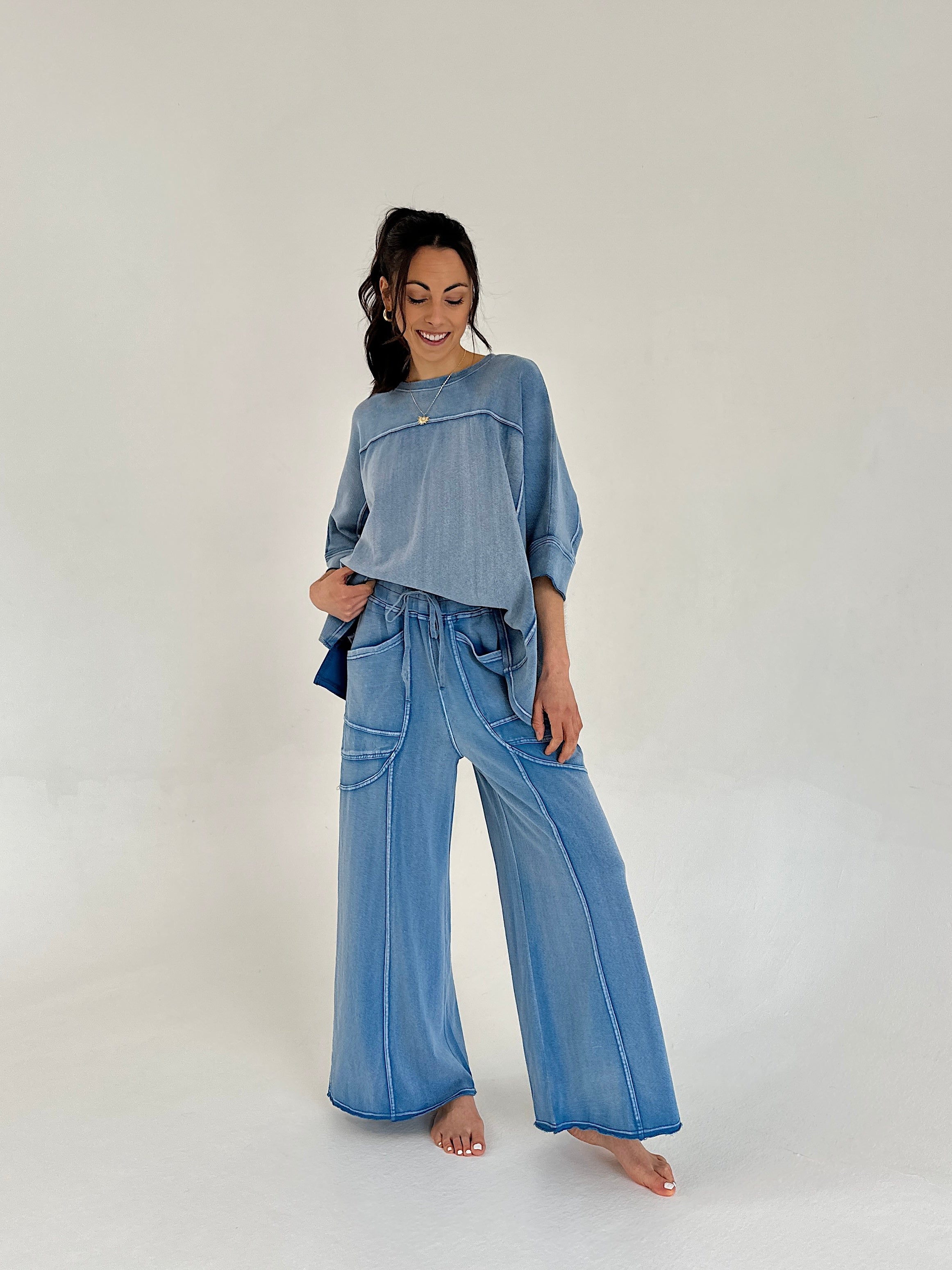 Woman wearing a blue outfit with wide-leg pants on a white background