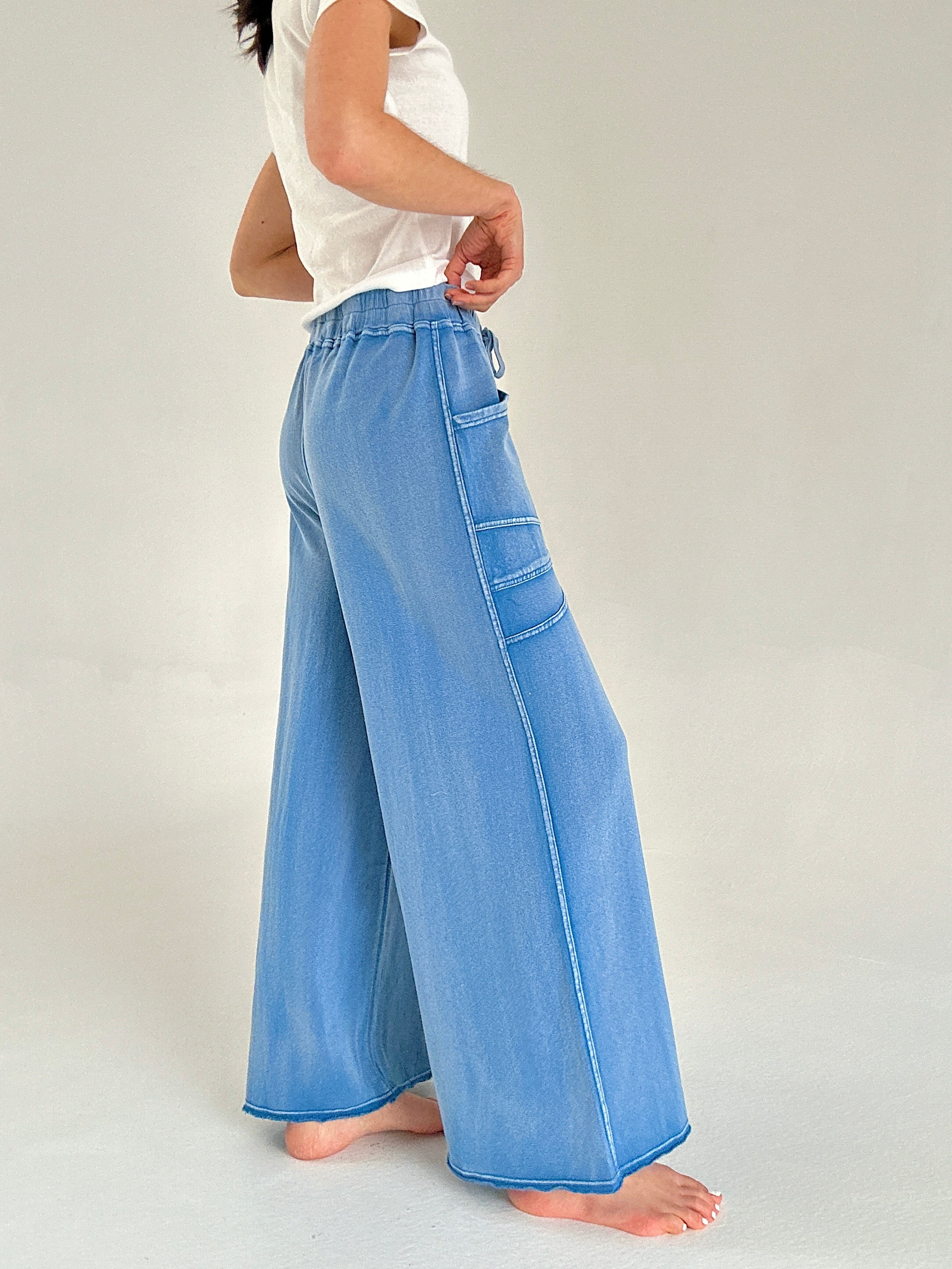 Blue wide-leg pants worn by a person on a plain background showing side