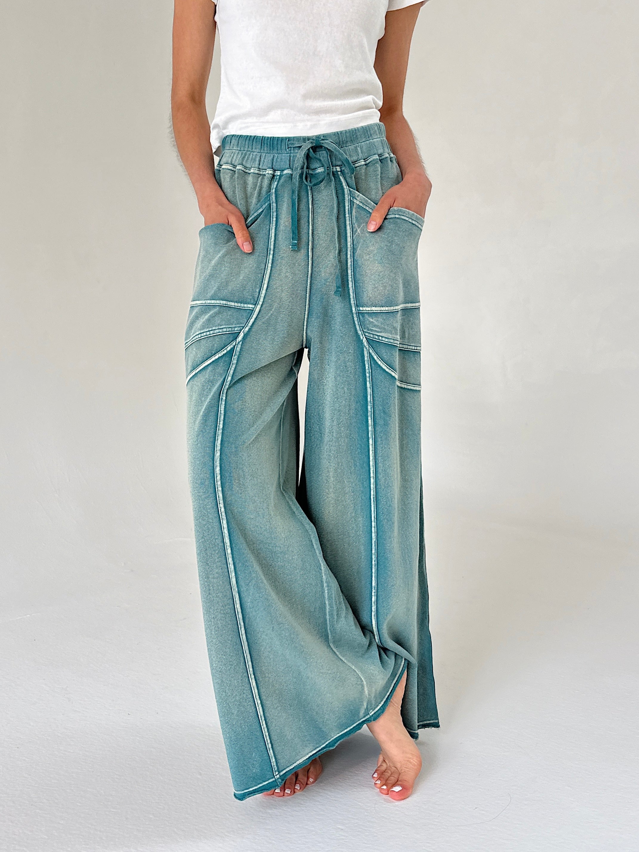 Person wearing teal wide-leg pants on a plain background