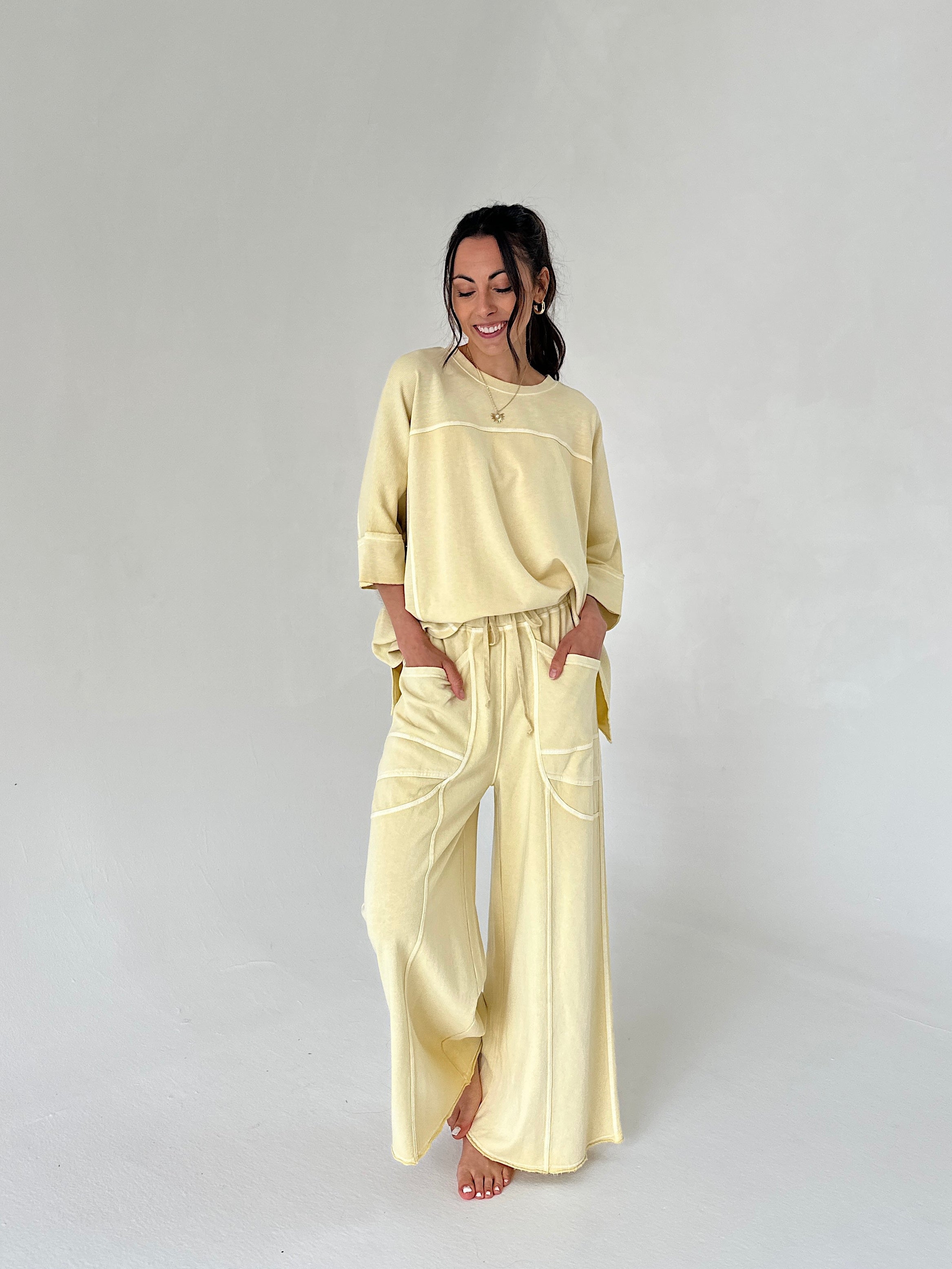 Woman wearing a light yellow outfit on a plain background