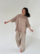 Woman wearing a camel brown matching outfit on a white background