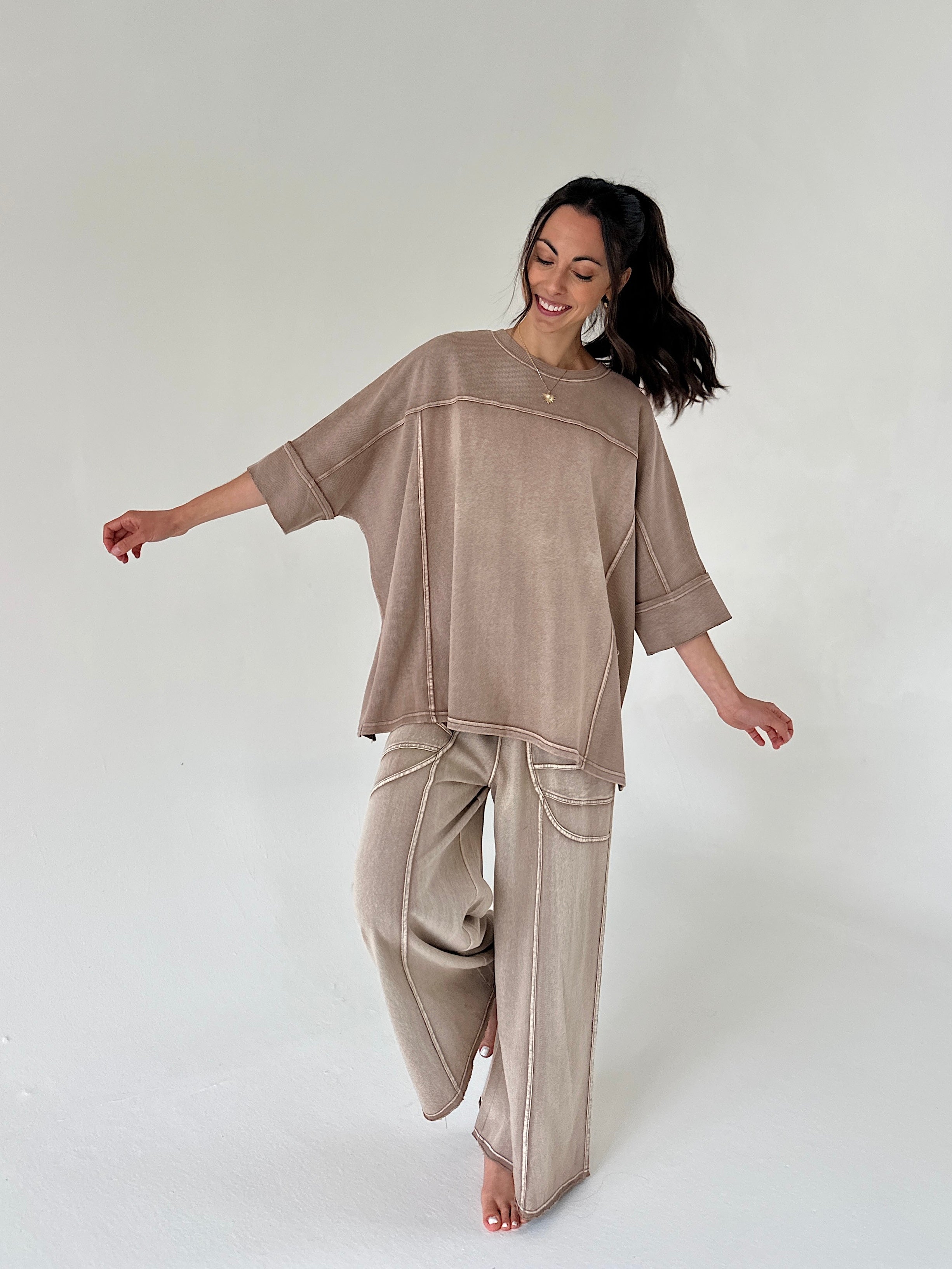 Woman wearing a camel brown matching outfit on a white background
