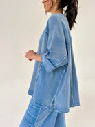 Person wearing a blue matching lounge outfit on a plain background showing top side