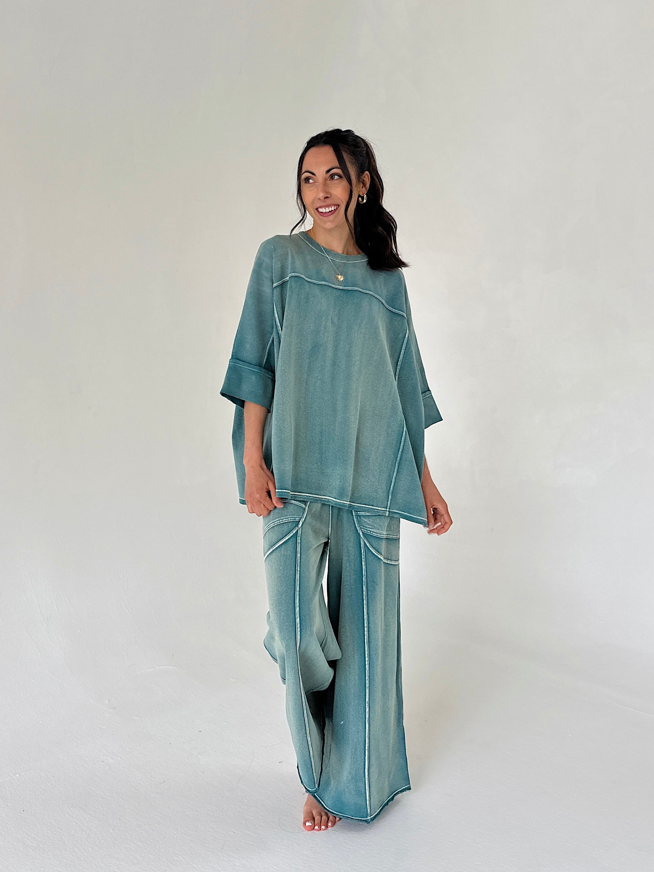 Woman wearing a teal outfit on a white background