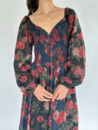 Floral dress with long sleeves on a plain background showing smocked top and sweetheart neckline