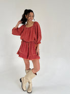 Woman wearing a red set with long sleeves and a white background