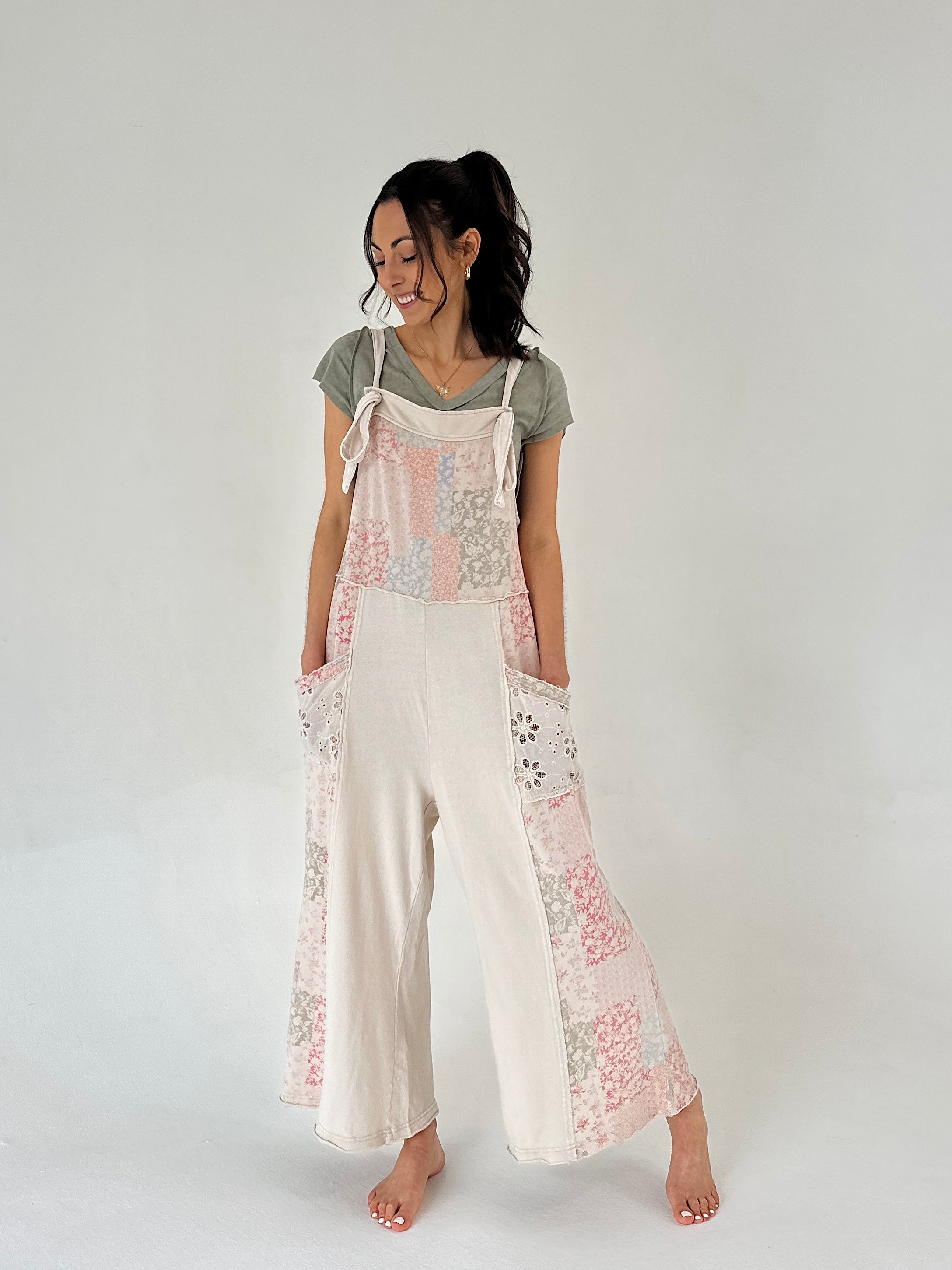 Woman wearing a terry knit jumper with patchwork print and side pockets on a plain background