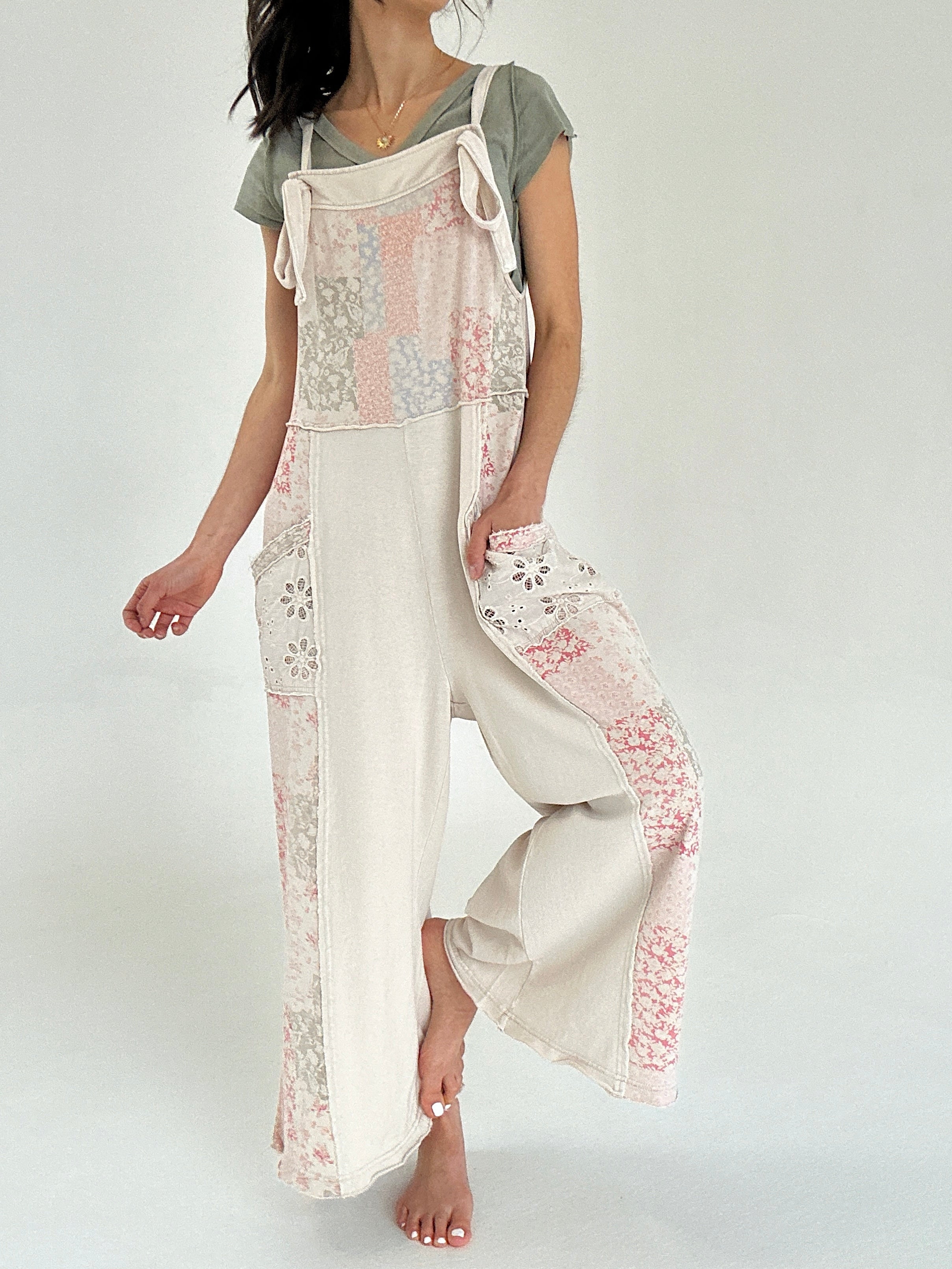 Person wearing a floral patchwork printed jumper over a plain green tee on a white background