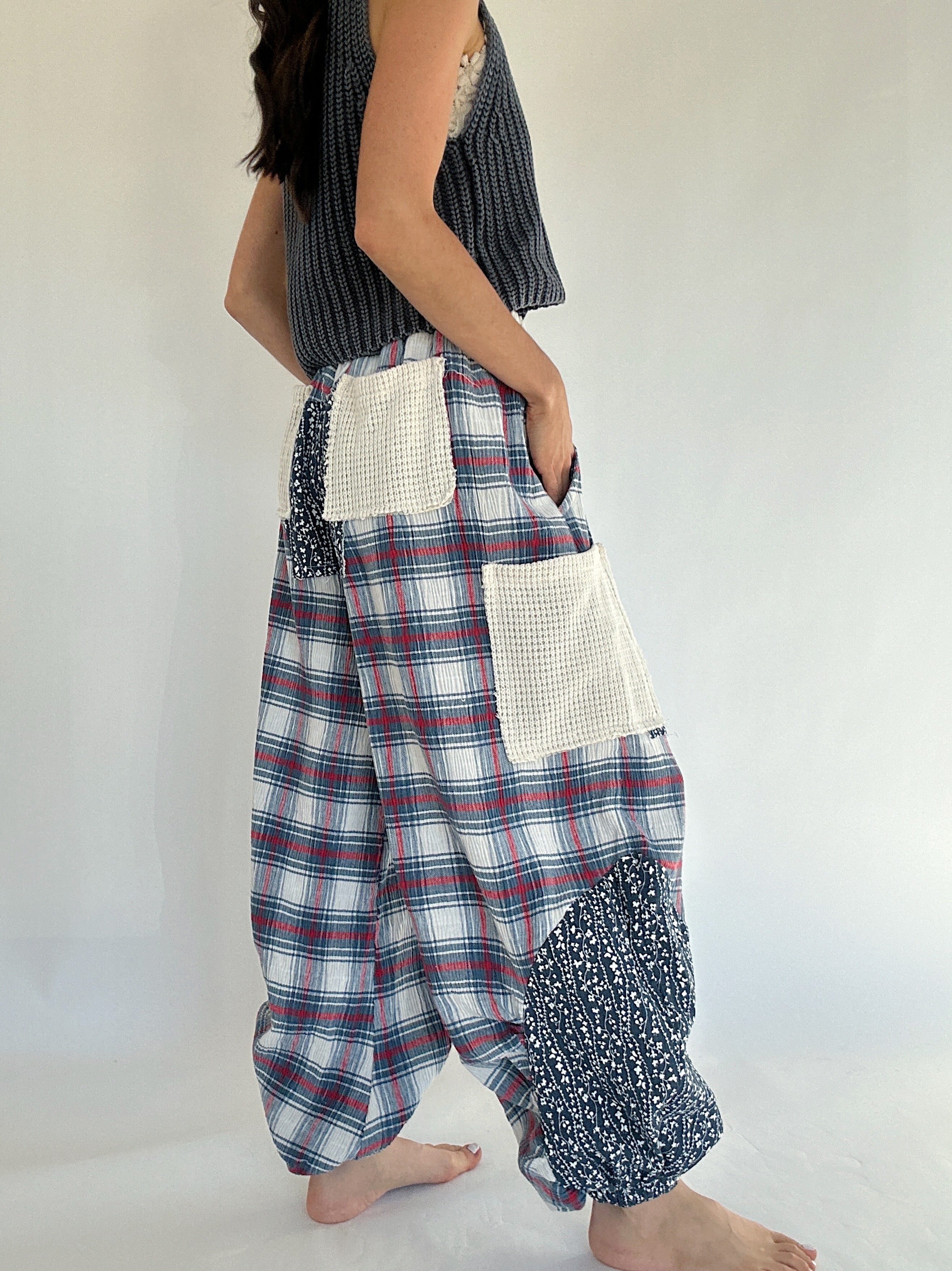 Person wearing plaid and patterned pants on a plain background