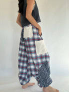 Person wearing plaid and patterned pants on a plain background