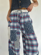 Person wearing plaid patchwork pants with a plain background - elastic drawstring waist