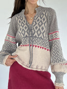 Person wearing a nordic patterned sweater with a plain background