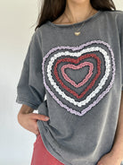 Gray t-shirt with a colorful textured heart design on a plain background