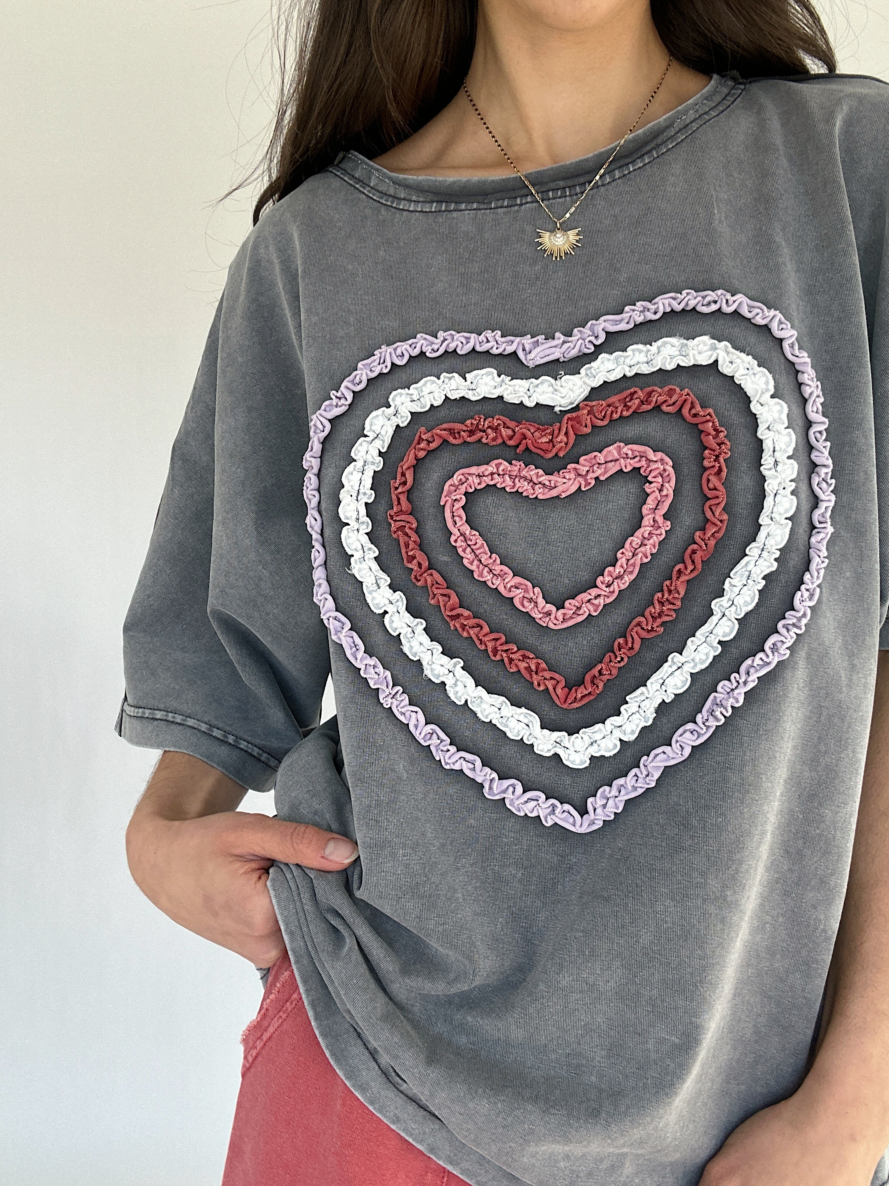 Gray t-shirt with a colorful textured heart design on a plain background