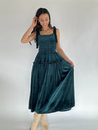 Woman wearing teal velvet midi dress