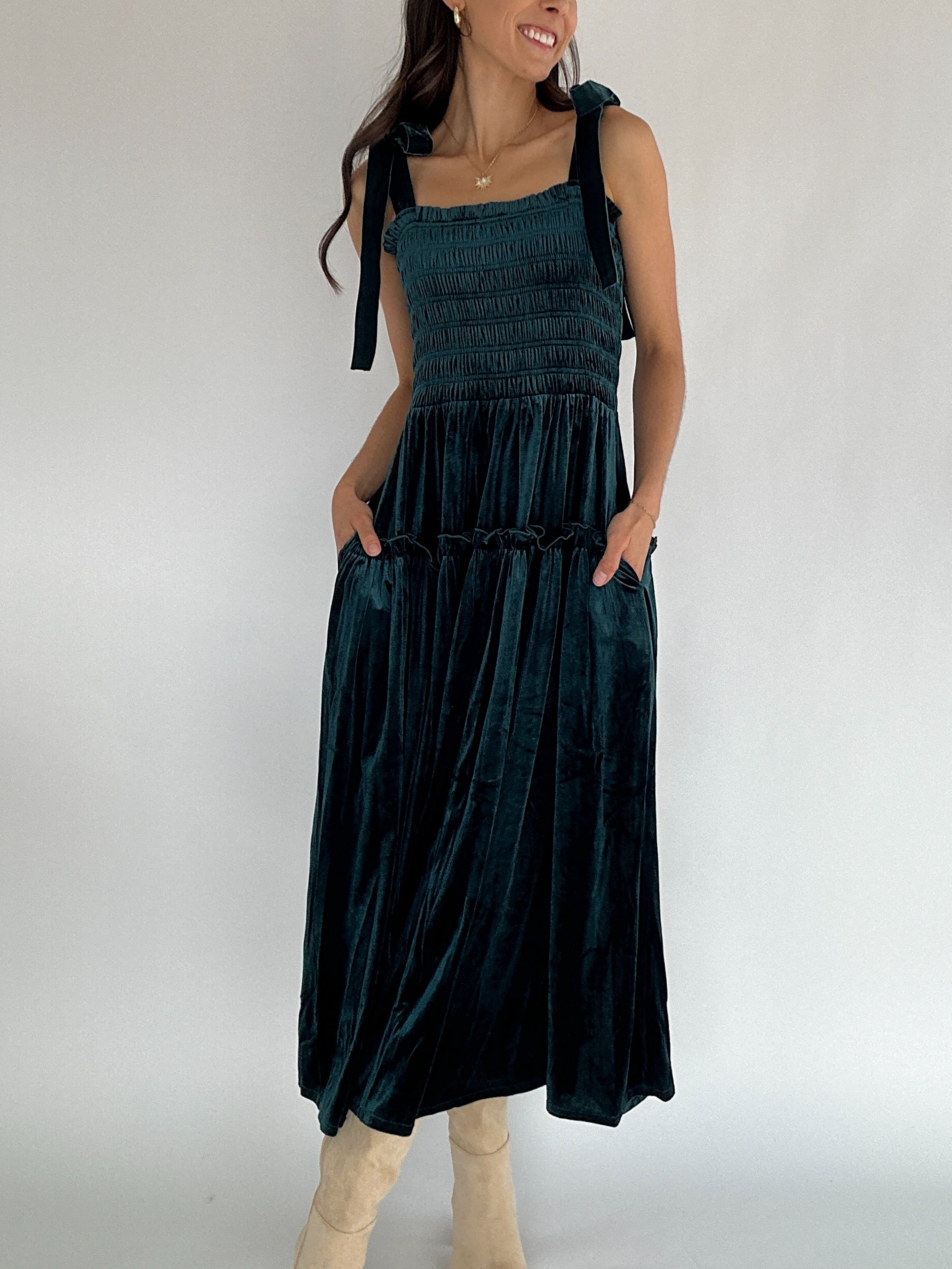 Woman wearing a dark green dress with a plain background