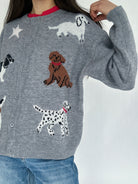 Person wearing a gray sweater with dog illustrations on a white background