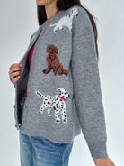 Person wearing a gray sweater with dog illustrations on a white background