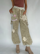 Light brown cargo jogger pants with decorative patches on a plain background