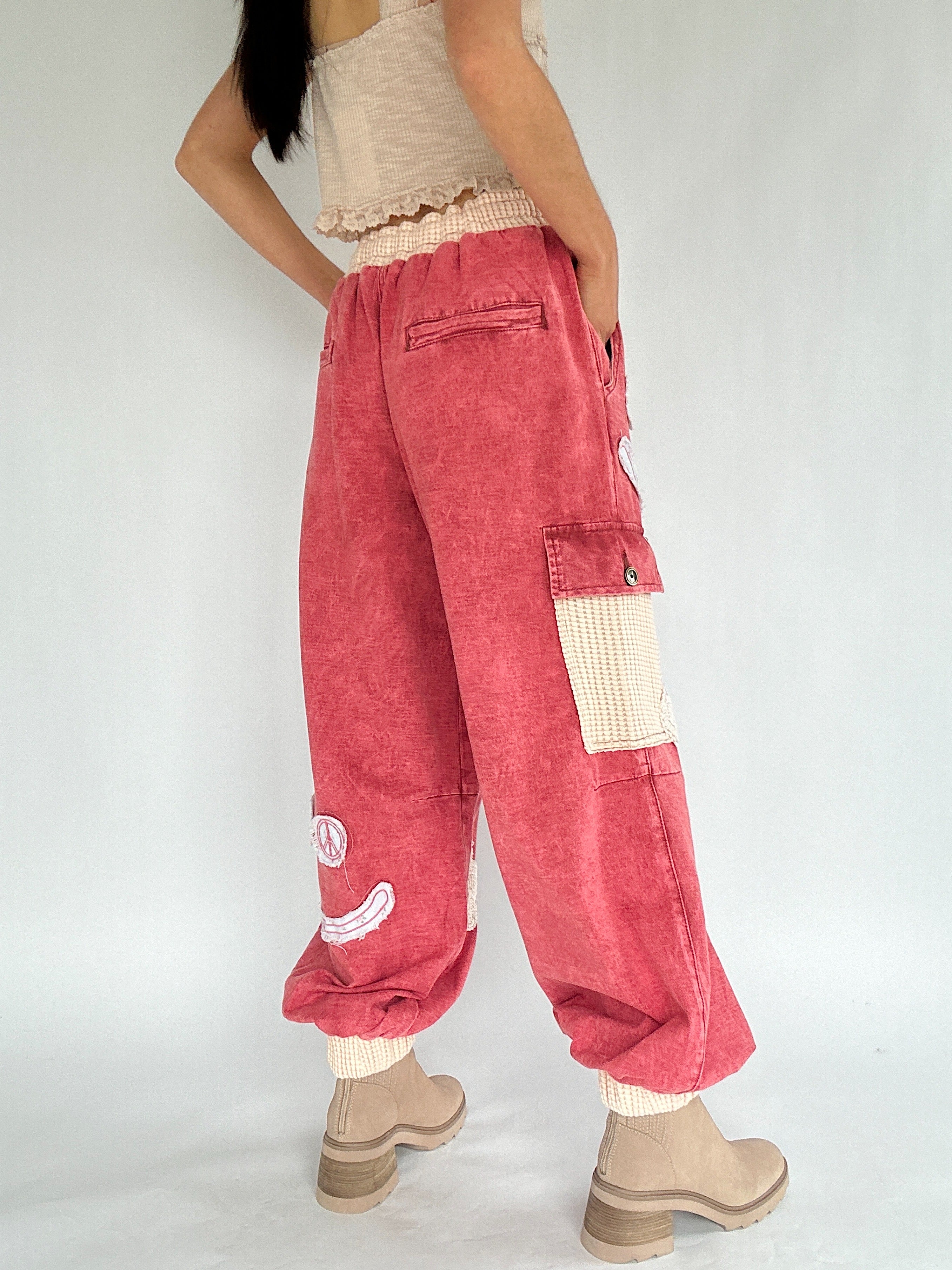 Person wearing red cargo pants with a white background