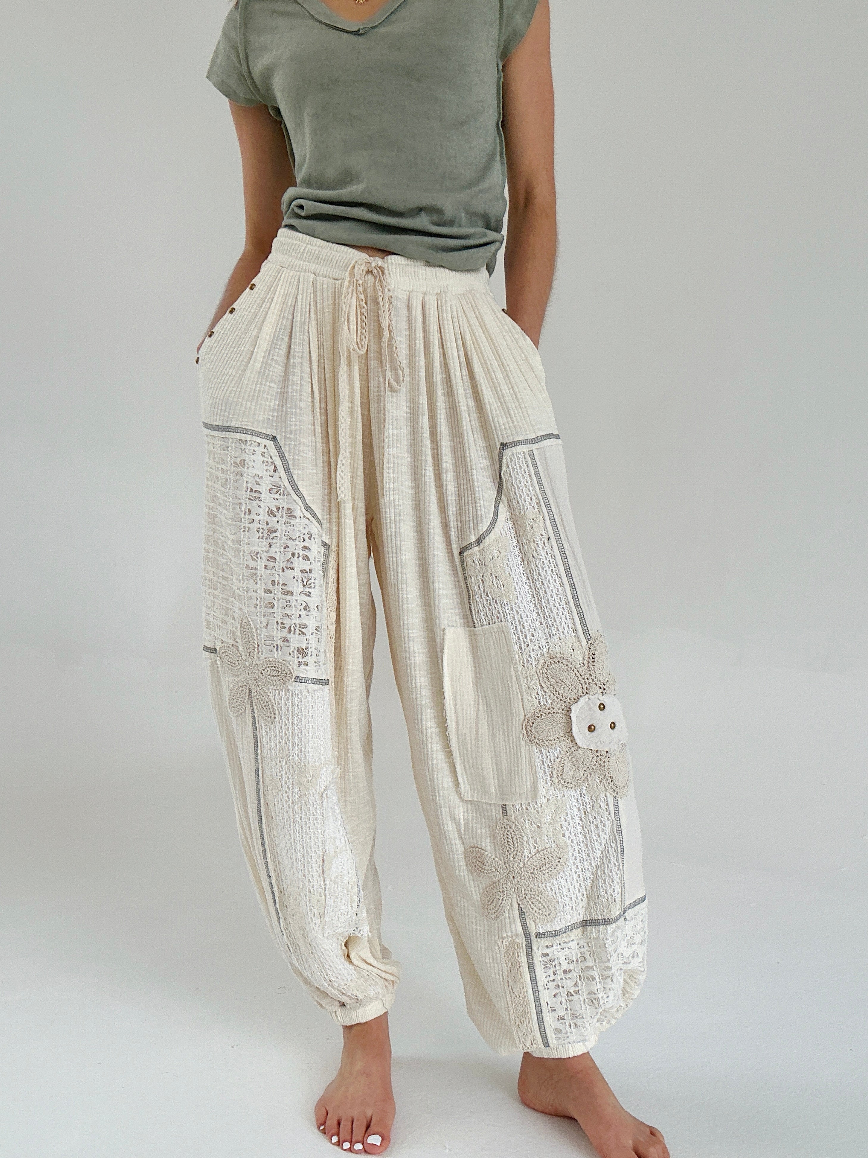 Person wearing beige patchwork jogger pants with a plain background