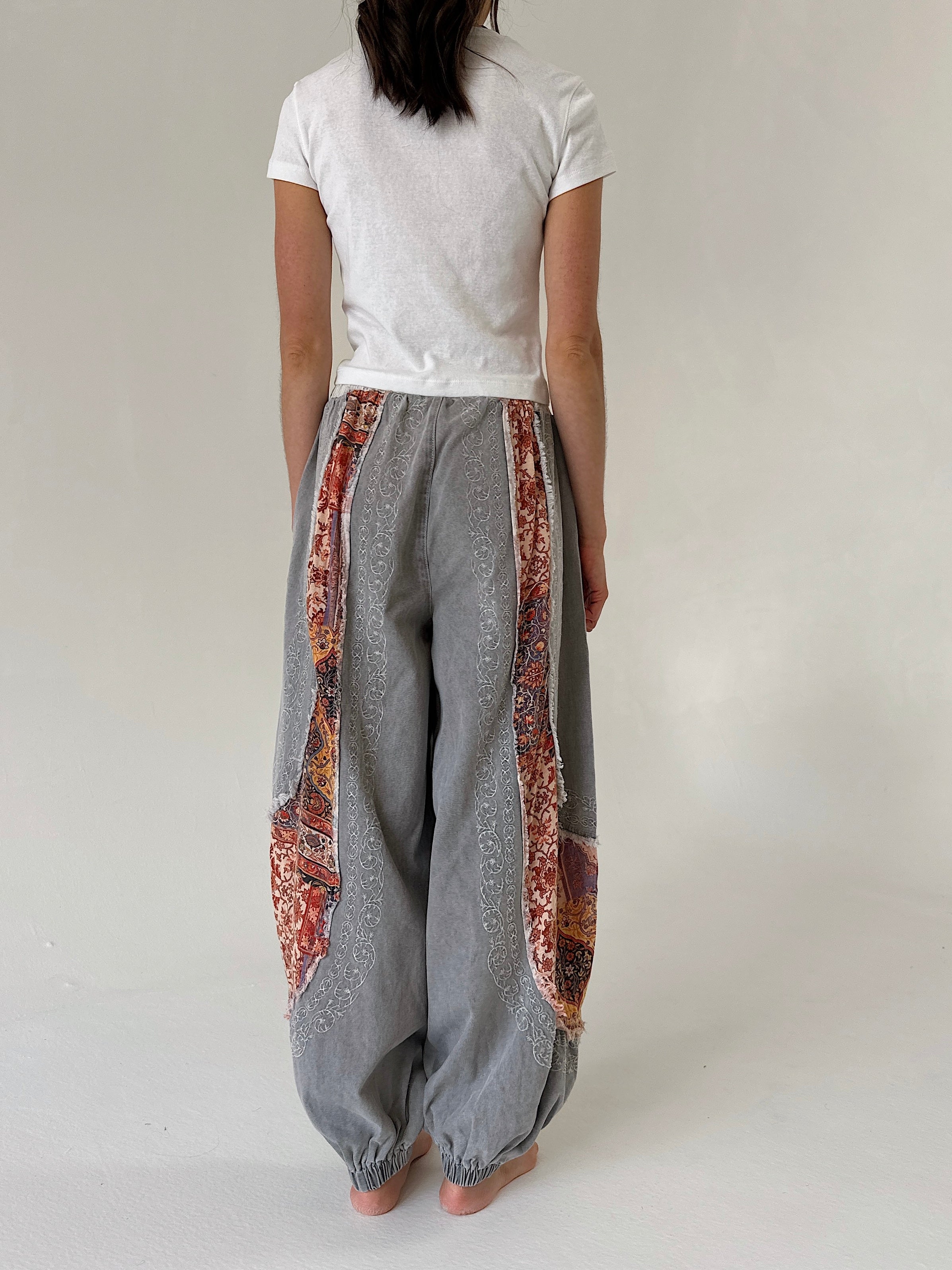 woman wearing charcoal jogger pants with floral accents from the back