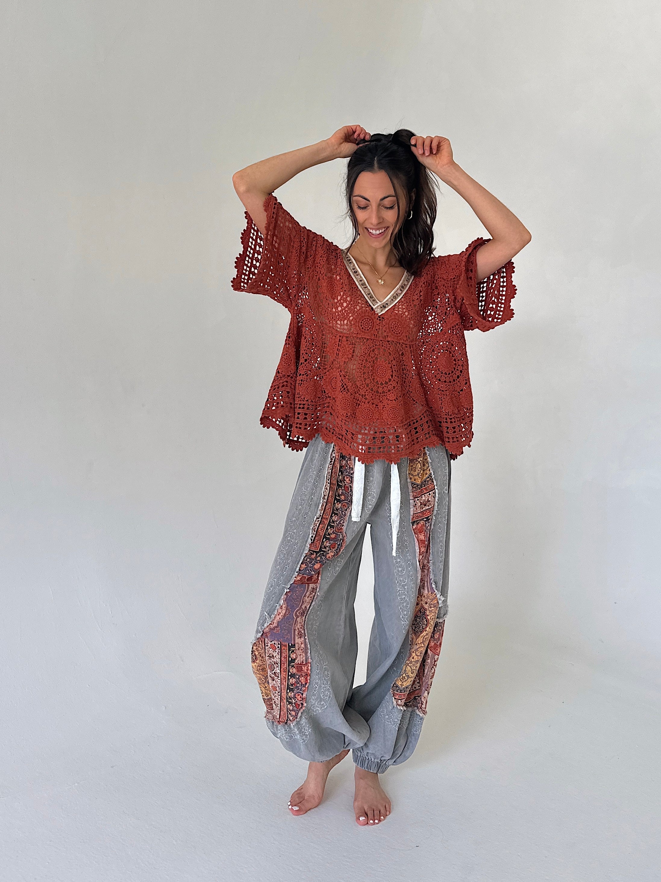 woman wearing a rust knit short sleeve top and grey jogger pants
